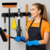 JIALTO Broom Holder and Mop Organizer | Mop Holder For Wall Without Drilling with 4 Slots and 5 Hooks for Kitchen, Garage, Garden, and Utility | Space Saving Cleaning Tool Organizer (Black)